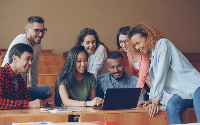 A group of people learning together around a laptop