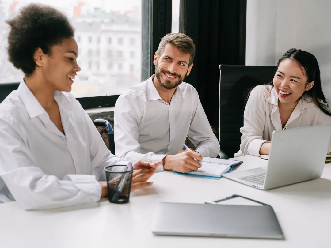 Three travel agents working through a client's trip together at a table