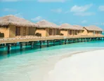 Thatched beach villas above a white-sand lagoon in the Maldives